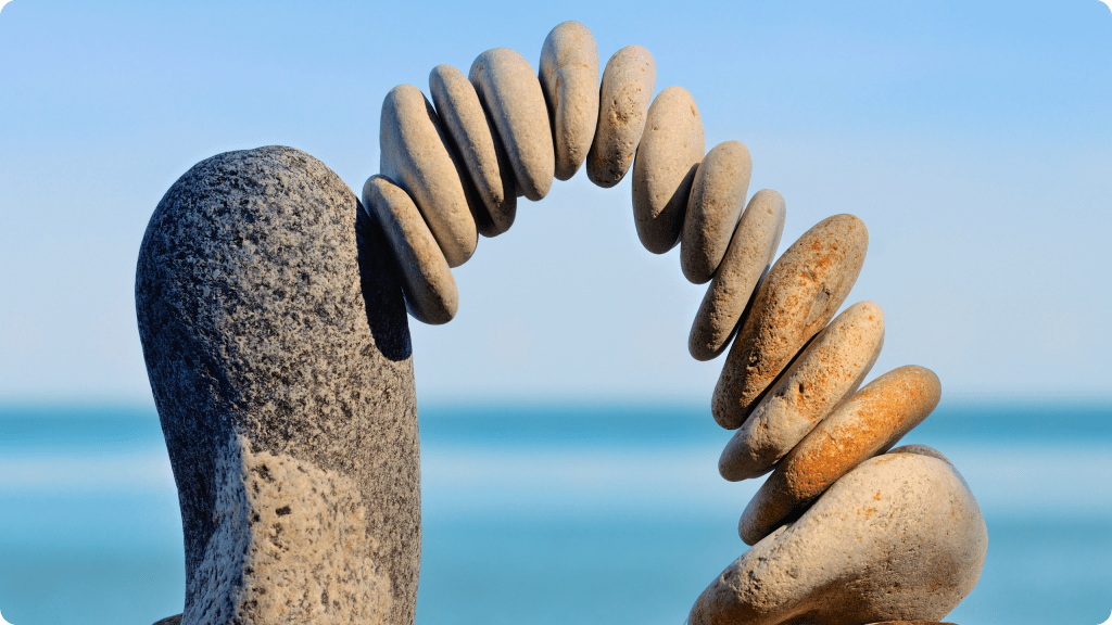 Emotional care and mindfulness connection – balanced stones forming a bridge representing clarity, empathy, and healthy relationships.