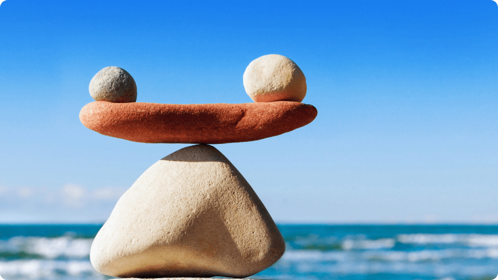 Emotional healing and mindfulness balance – stacked stones on the beach representing how emotional care restores calm to body and mind.”